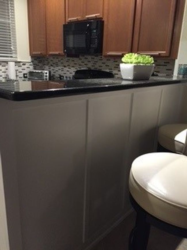 Kitchen with black microwave, dark countertops, decorative backsplash, and brown cabinetry | Image 15