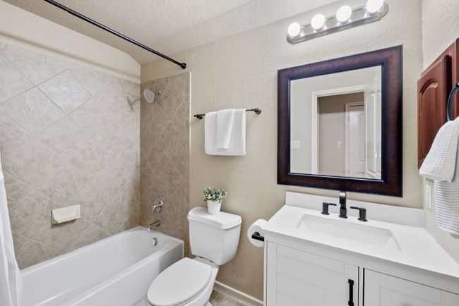 Full bath with shower / washtub combination, vanity, a textured ceiling, and a textured wall | Image 25