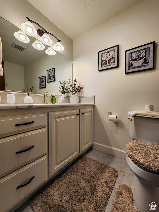 Half bathroom featuring visible vents, tile patterned flooring, vanity, baseboards, and toilet | Image 21