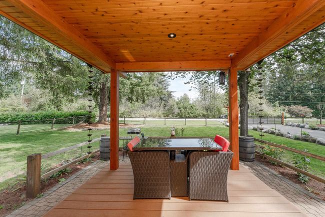 Wooden deck with outdoor dining space and view of wooded area | Image 25