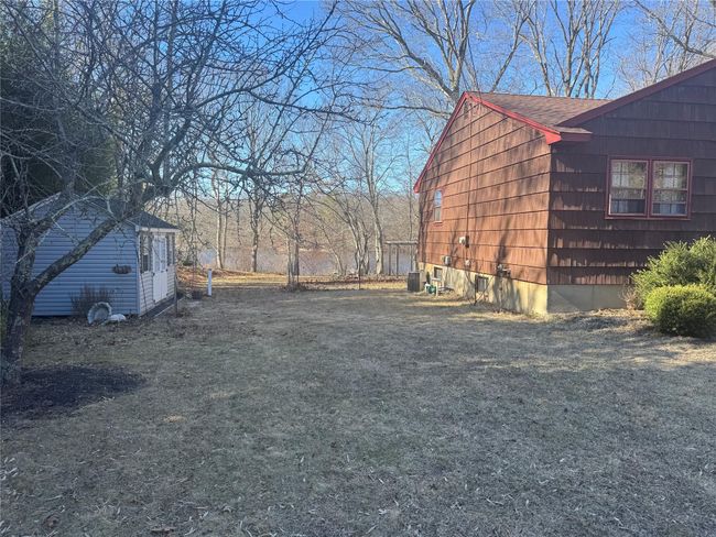 View of property exterior featuring an outbuilding, central AC, and roof with shingles | Image 21