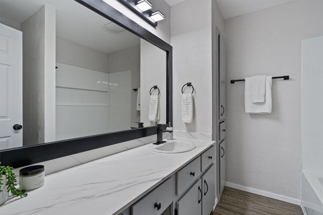 Bathroom with wood finished floors, vanity, and shower / bathtub combination | Image 14