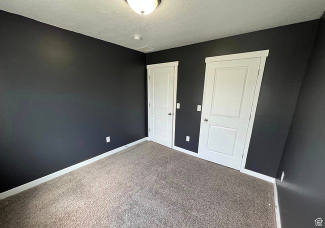 Unfurnished bedroom with carpet floors and a textured ceiling | Image 21