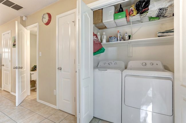 Clothes washing area featuring washing machine and dryer, light tile patterned floors, and baseboards | Image 29
