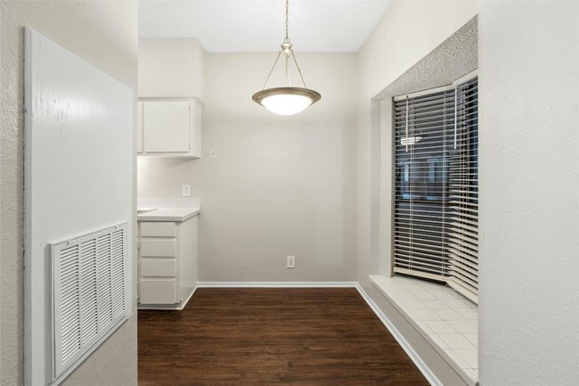 Unfurnished dining area featuring visible vents, wood finished floors, and baseboards | Image 14