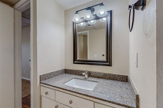 A modern wet room showcasing a vanity unit with a lighted mirror and a towel holder on the wall, designed for comfort and functionality. | Image 23