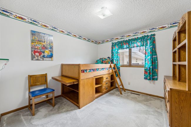 3rd bedroom on the main level with plush carpet and a large window filling the room with natural light | Image 13