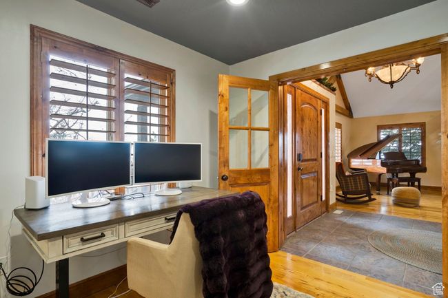 Office area featuring baseboards, vaulted ceiling, wood finished floors, and a chandelier | Image 14