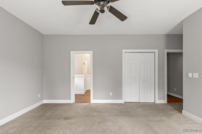 Unfurnished bedroom with carpet, a closet, baseboards, a ceiling fan, and connected bathroom | Image 27