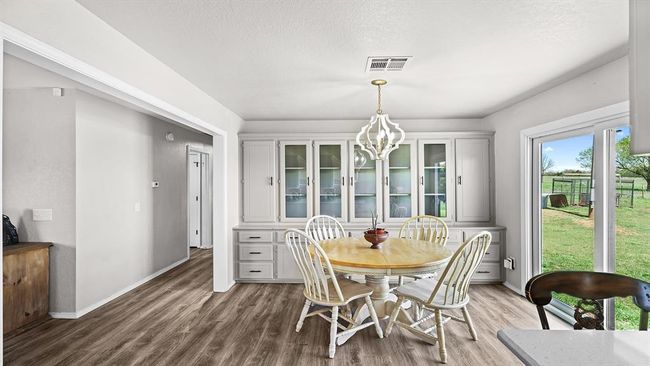 Dining room featuring visible vents, baseboards, an inviting chandelier, and wood finished floors | Image 32