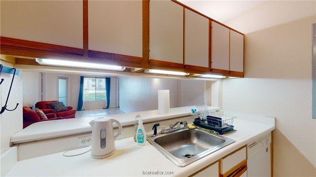 Kitchen featuring dishwasher, kitchen peninsula, sink, and white cabinets | Image 10