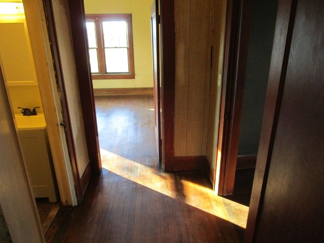 Corridor featuring a sink, baseboards, and hardwood / wood-style flooring | Image 14