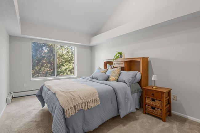 The spacious primary bedroom boasts 12-foot vaulted ceilings, plush carpeted flooring, three closets, and a linen closet. It offers private access to the full bathroom, which can also be reached from the hallway near the front door. | Image 8