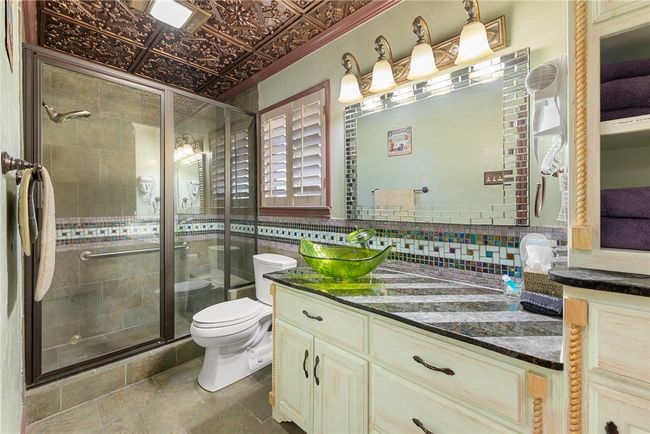 Bathroom with toilet, a shower stall, vanity, and decorative backsplash | Image 15