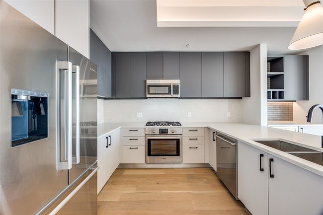 Kitchen with sink, appliances with stainless steel finishes, backsplash, white cabinets, and light wood-type flooring | Image 5