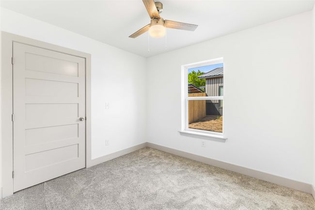 Carpeted empty room featuring ceiling fan and baseboards | Image 24