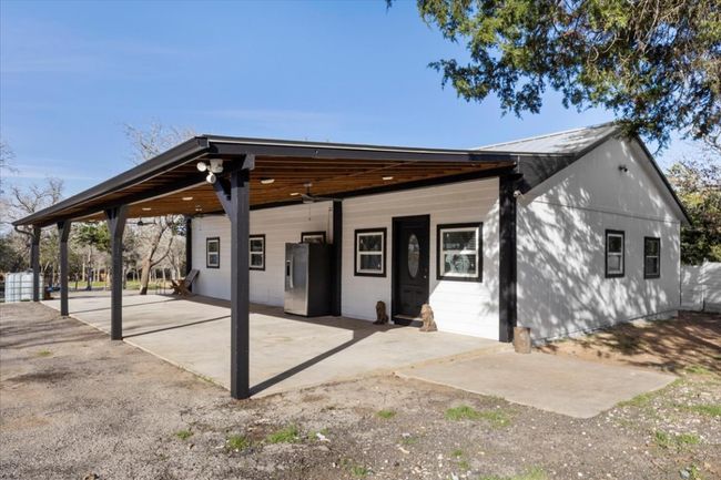 View of front facade featuring a patio area, metal roof, and a carport | Image 4