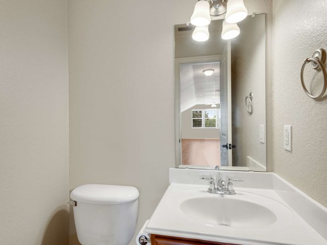 Half bath with vanity, a textured wall, and a chandelier | Image 20