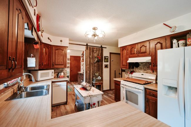 Kitchen with a window facing to back yard so you can watch the kids play and run around or just look out into your over 1/2 acre yard. Laundry with sliding privacy door on the main level. W/D do not stay. Steel door goes out to the oversized garage. | Image 7