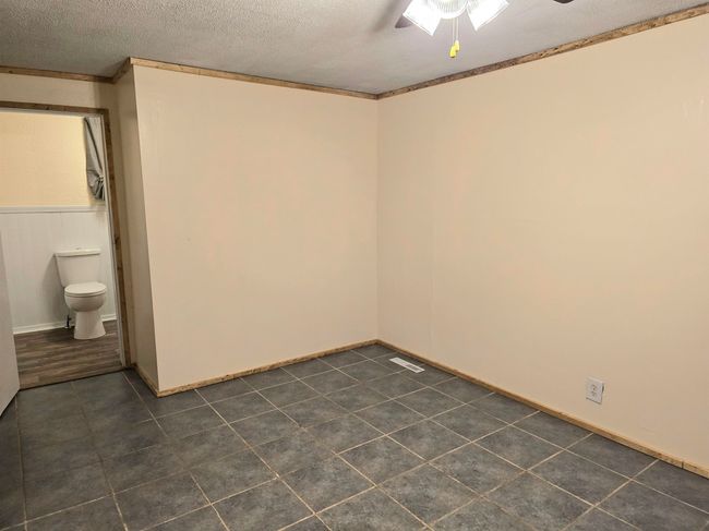 Spare room featuring ceiling fan, a textured ceiling, and crown molding | Image 19