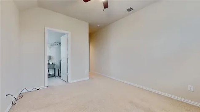 Unfurnished bedroom featuring carpet flooring, ceiling fan, and a spacious closet | Image 11