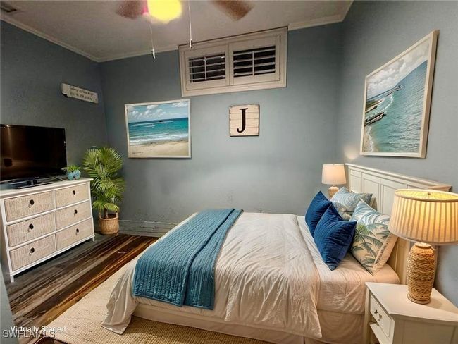 Bedroom featuring baseboards, wood finished floors, ceiling fan, and crown molding | Image 18
