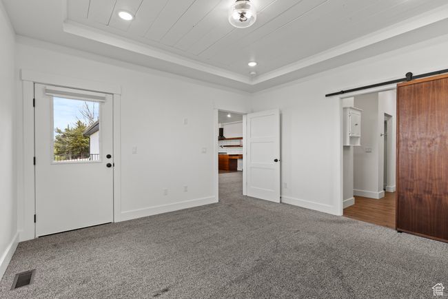Foyer with a raised ceiling, carpet, recessed lighting, baseboards, and a barn door | Image 16
