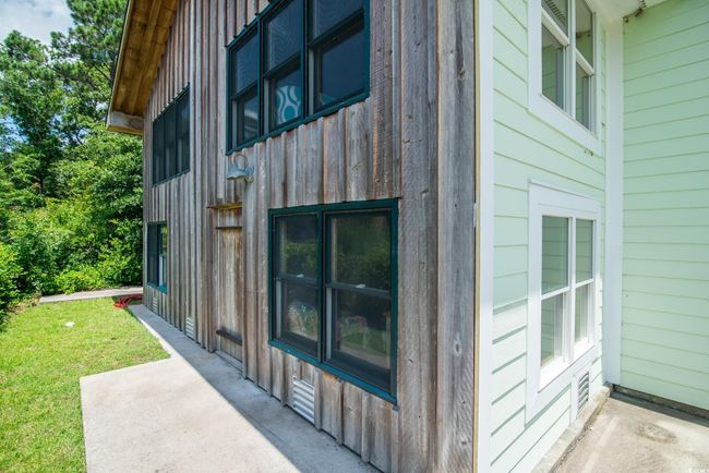 View of home's exterior with board and batten siding, a patio, and a yard | Image 4