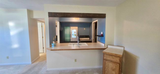 Kitchen featuring dishwasher, brown cabinets, a sink, light countertops, and beam ceiling | Image 11