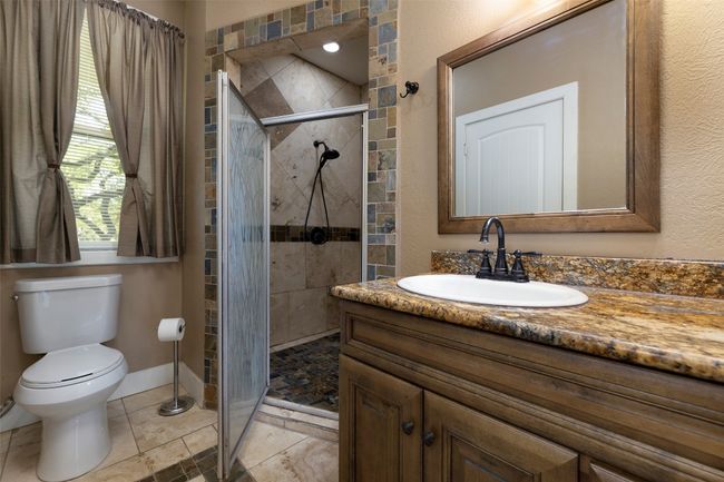Bathroom featuring vanity, a shower stall, toilet, and baseboards | Image 16