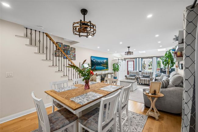 Dining room with light wood-style floors, recessed lighting, a chandelier, baseboards, and stairway | Image 10