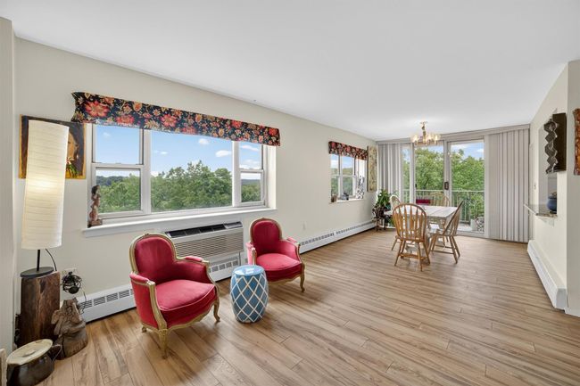 Living area with a baseboard radiator, a chandelier, a baseboard heating unit, and wood finished floors | Image 12