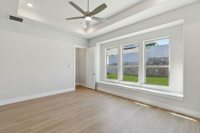 Unfurnished room featuring a raised ceiling, light wood-style flooring, a ceiling fan, and recessed lighting | Image 19