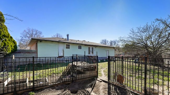 Back of house with a yard, fence, french doors, and a vegetable garden | Image 27