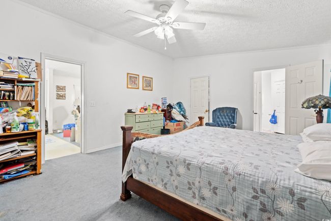 Carpeted bedroom with a textured ceiling and ceiling fan | Image 11