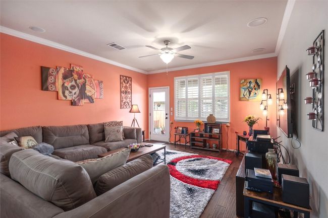 Living room featuring a ceiling fan, hardwood / wood-style flooring, and ornamental molding | Image 8
