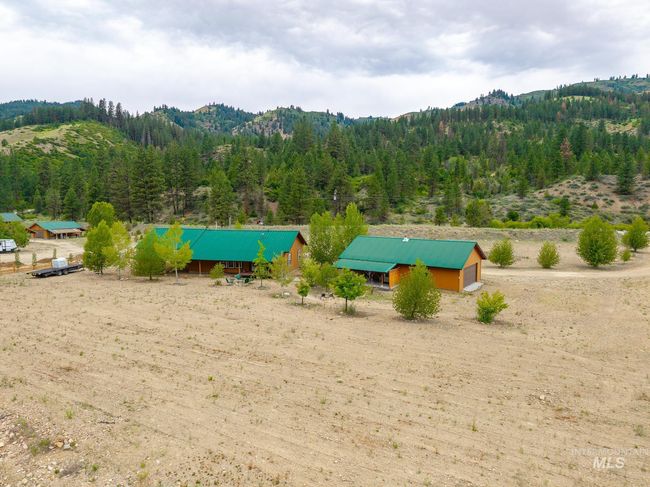 View of yard featuring a wooded view, an outdoor structure, a mountain view, and a pole building | Image 23