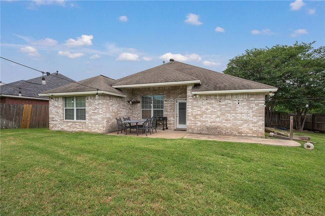 Rear view of house with a patio area, brick siding, and roof with shingles | Image 14