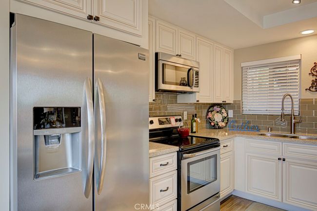 Upgraded kitchen features ample cabinet storage with soft-close drawers, quartz countertops with a ceramic tile backsplash, Frigidaire stainless steel appliances and more. | Image 16