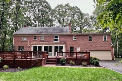 Rear view of house with a deck, a yard, and a garage | Image 2