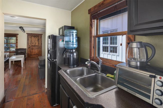 Kitchen featuring ornamental molding, dark wood-style floors, freestanding refrigerator, and a sink | Image 15