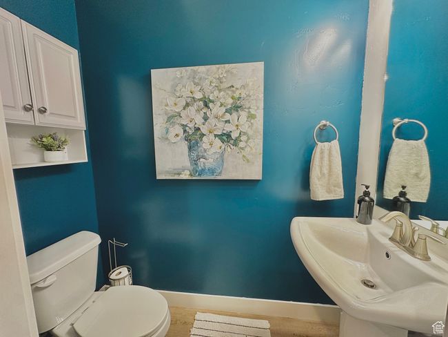 Bathroom featuring toilet, baseboards, and a sink | Image 9