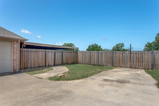 Double open gates to backyard, and covered storage area | Image 30