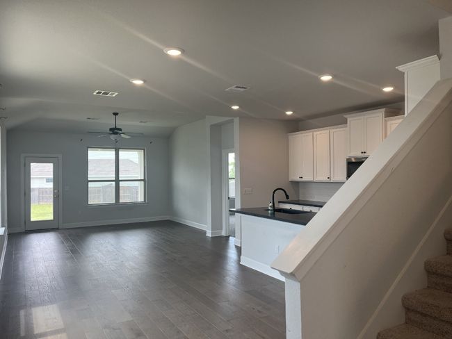 Kitchen featuring visible vents, baseboards, ceiling fan, white cabinets, and a sink | Image 23