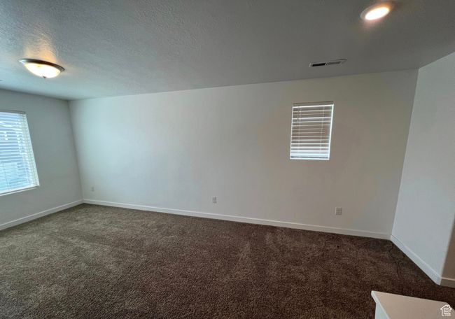 Unfurnished room featuring dark carpet and a textured ceiling | Image 10