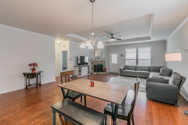 Dining space with a stone fireplace, a chandelier, and wood-type flooring | Image 21
