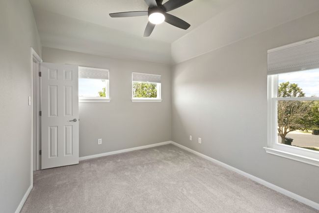 Carpeted spare room featuring healthy amount of natural light, ceiling fan, and baseboards | Image 27