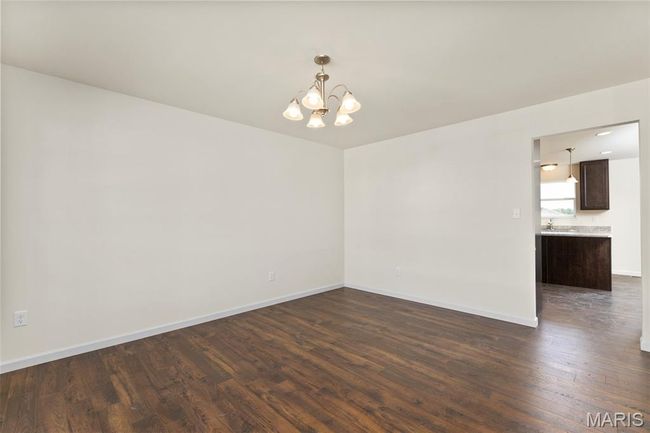 Empty room featuring a chandelier and dark wood finished floors | Image 5