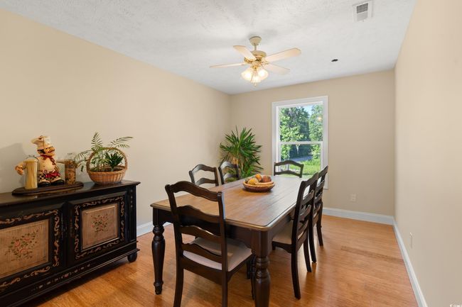 Dining room with light wood-style floors, baseboards, and ceiling fan | Image 9