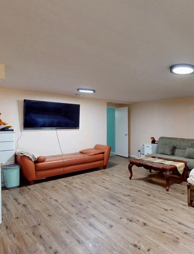 Unfinished below grade area featuring washer / dryer, a sink, gas water heater, and a water pressure tank | Image 40
